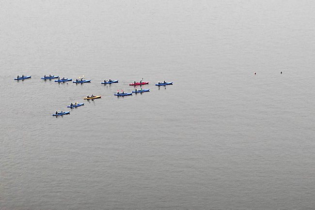 Kayaks paddle in a geese-like V-formation during Patrick Scully's boat ballet on the Havel River at Potsdam, Germany in 2010. (Photo courtesy of Patrick Scully, cribbed from StarTribune.com)